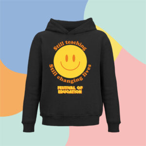 Black hoodie with a large yellow smiling face graphic and orange circular text, shown against a pastel abstract background.