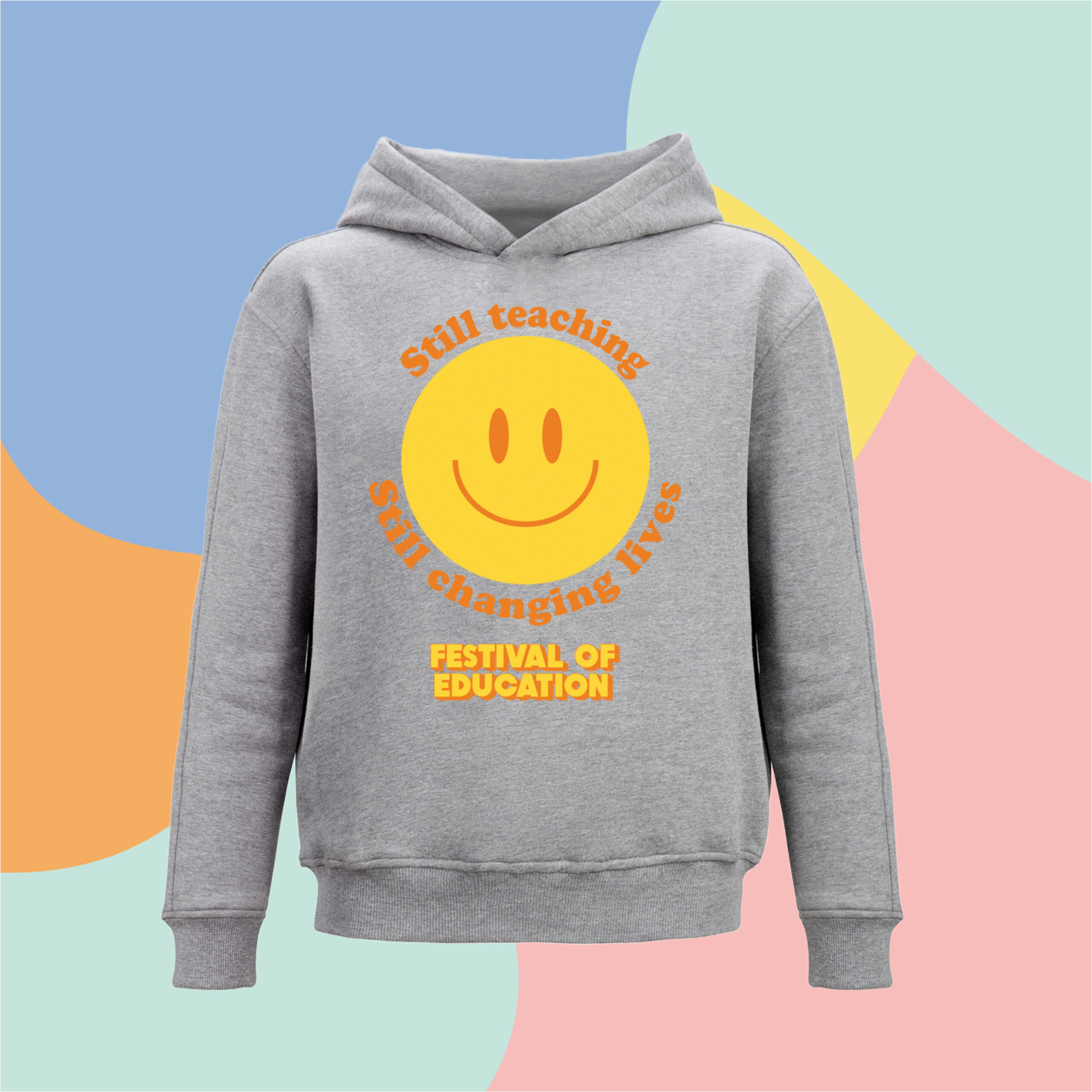 Grey Smiley hood front | UK Festival of Education Gray hoodie featuring a large yellow smiley face with orange text around it reading 'Still teaching', set against a colorful abstract background.